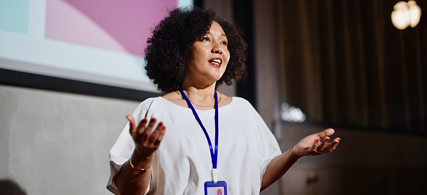 woman speaking on stage at a conference