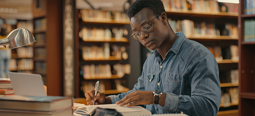 man researching at a library table